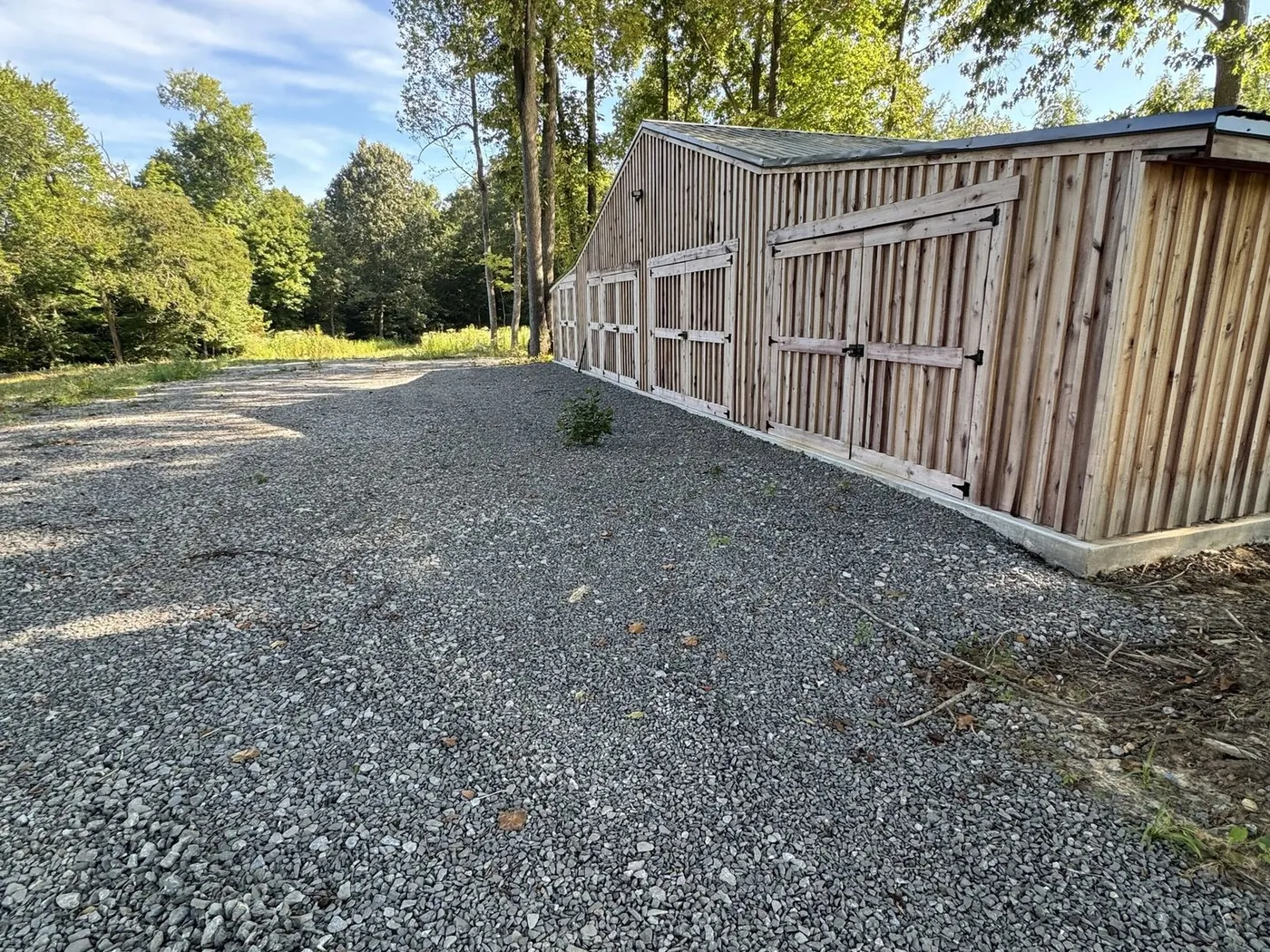 Gravel driveway running along a barn