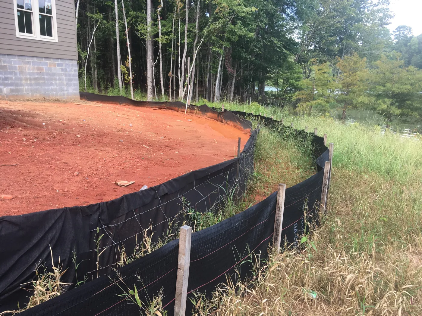 Silt fence set around a graded red clay building pad